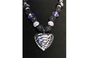 Necklace with black fabric and white, purple and black glass heart pendant